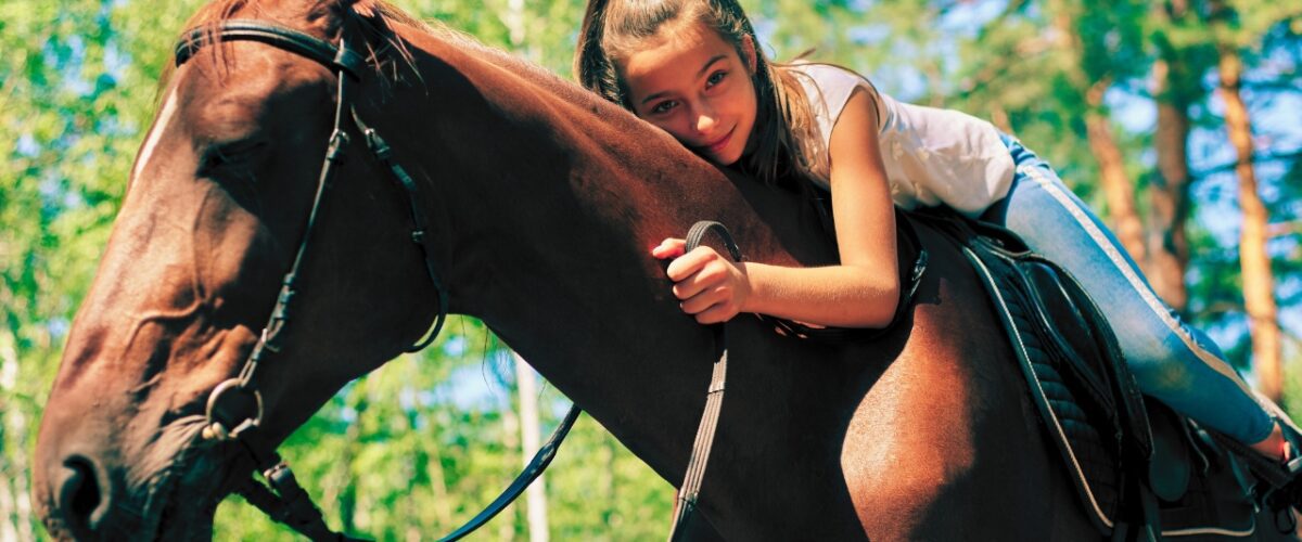 Girl lying down on a horse as part of horse riding venues in Pretoria