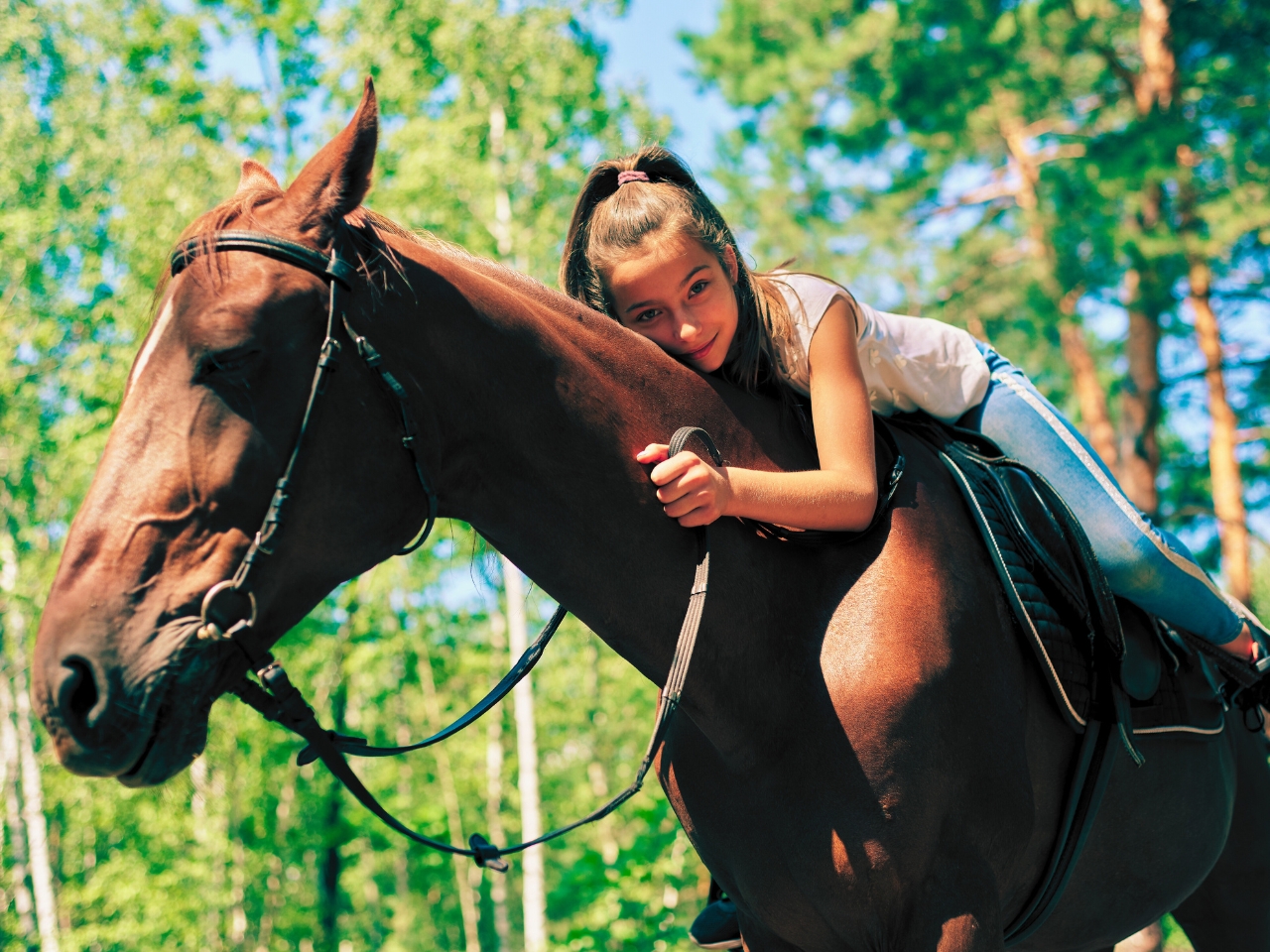 Girl lying down on a horse as part of horse riding venues in Pretoria