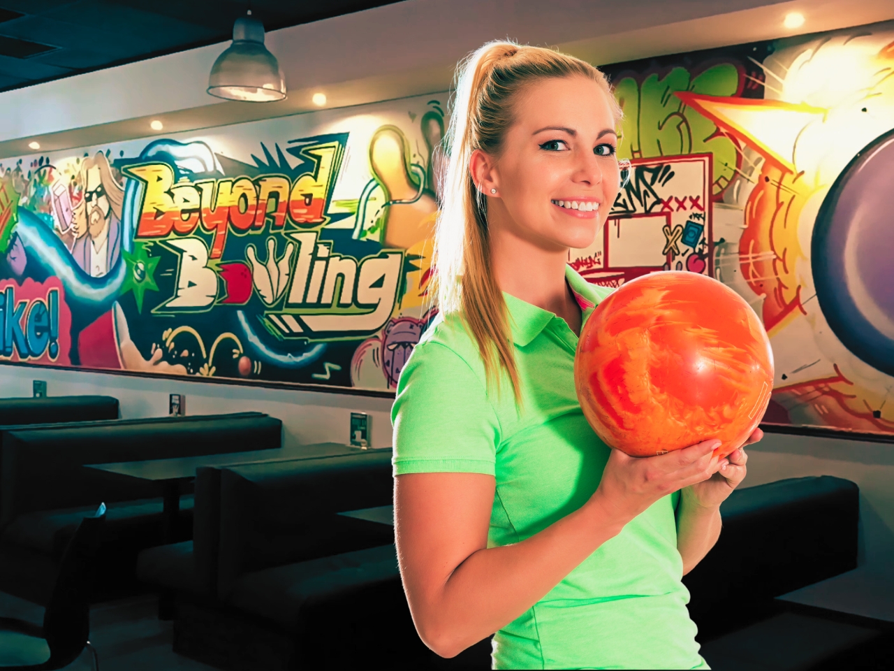 An attractive woman with a bowling ball in her hand at a ten pin bowling venue in Pretoria