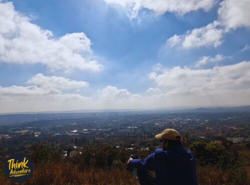 A hiker at a High Point of View on the Red Trail at the Klapperkop Nature Reserve