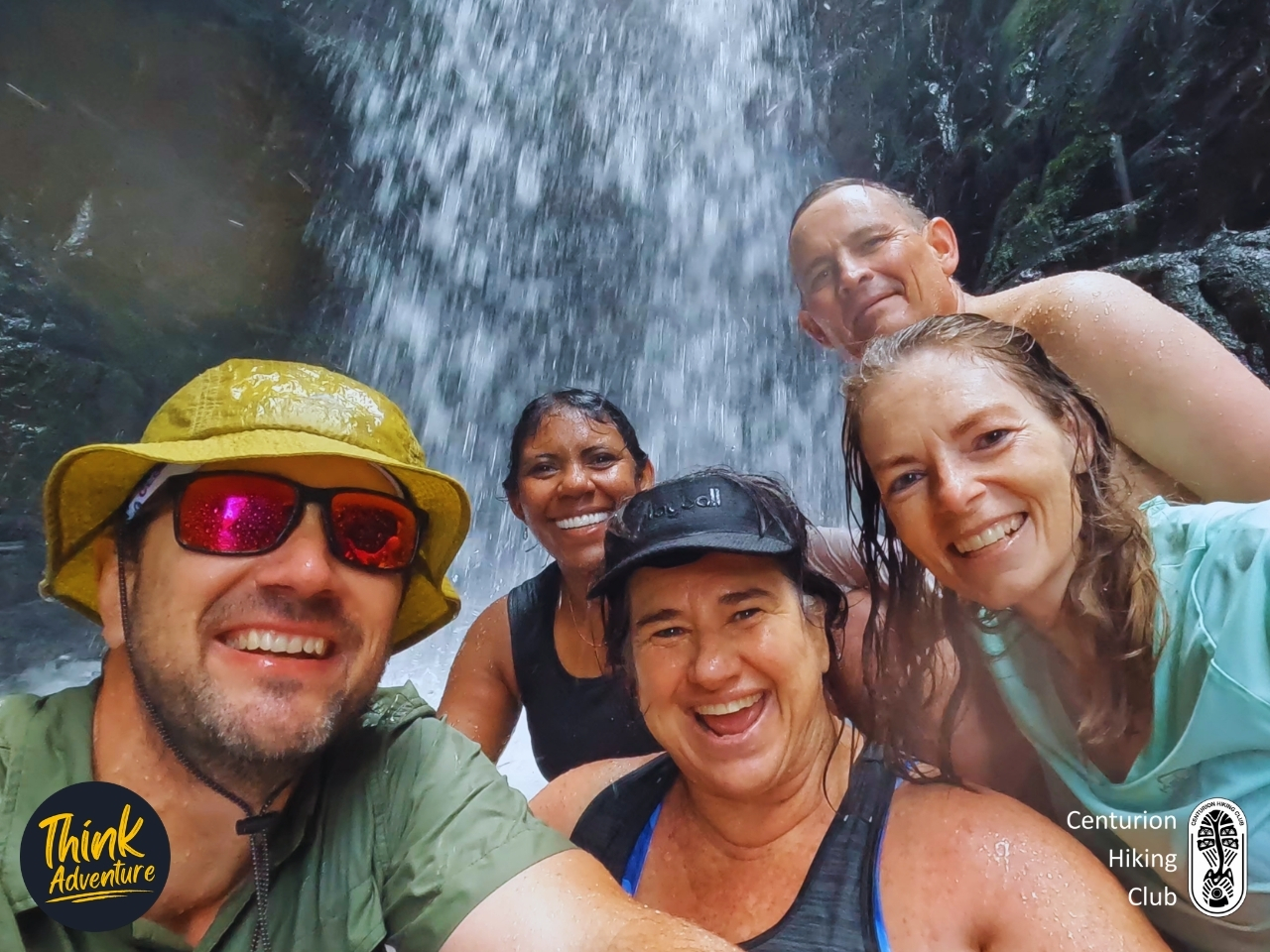 5 wet, smiling hikers taking a GoPro selfie under the waterfall in Bald Ibis Gorge on the Bosbok Trail, Wathaba Hiking Trails