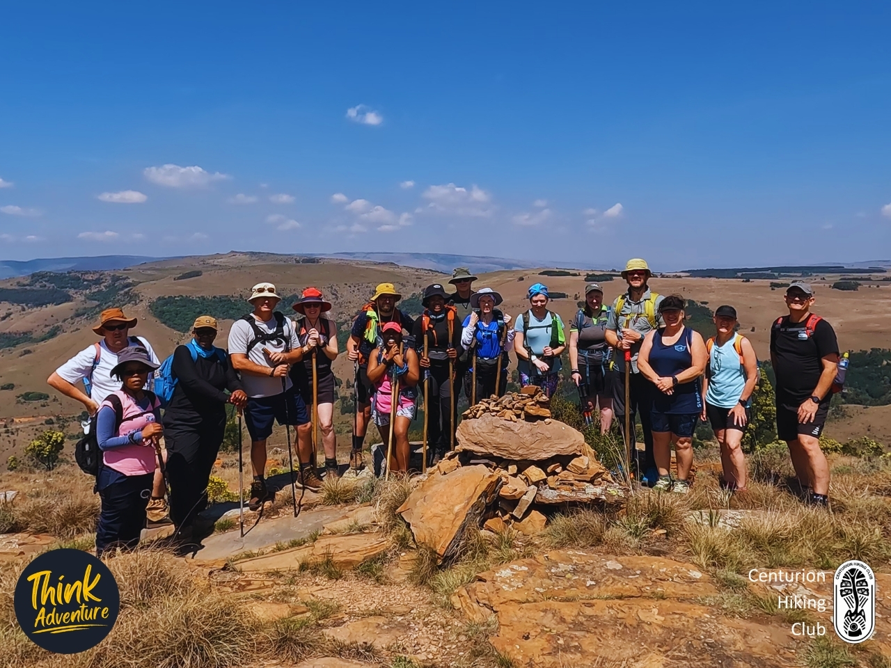 Hikers on a grassy ridge at the highest point of the Lynx Loop, with forested valleys behind, at Wathaba Hiking Trails